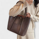 Brown croc-embossed leather tote bag with wide handles and open top
