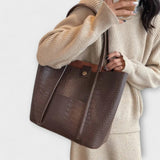 Brown croc-embossed leather tote bag with wide handles and open top