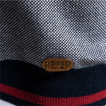 Waistband stripes and round size label on navy knit sweater