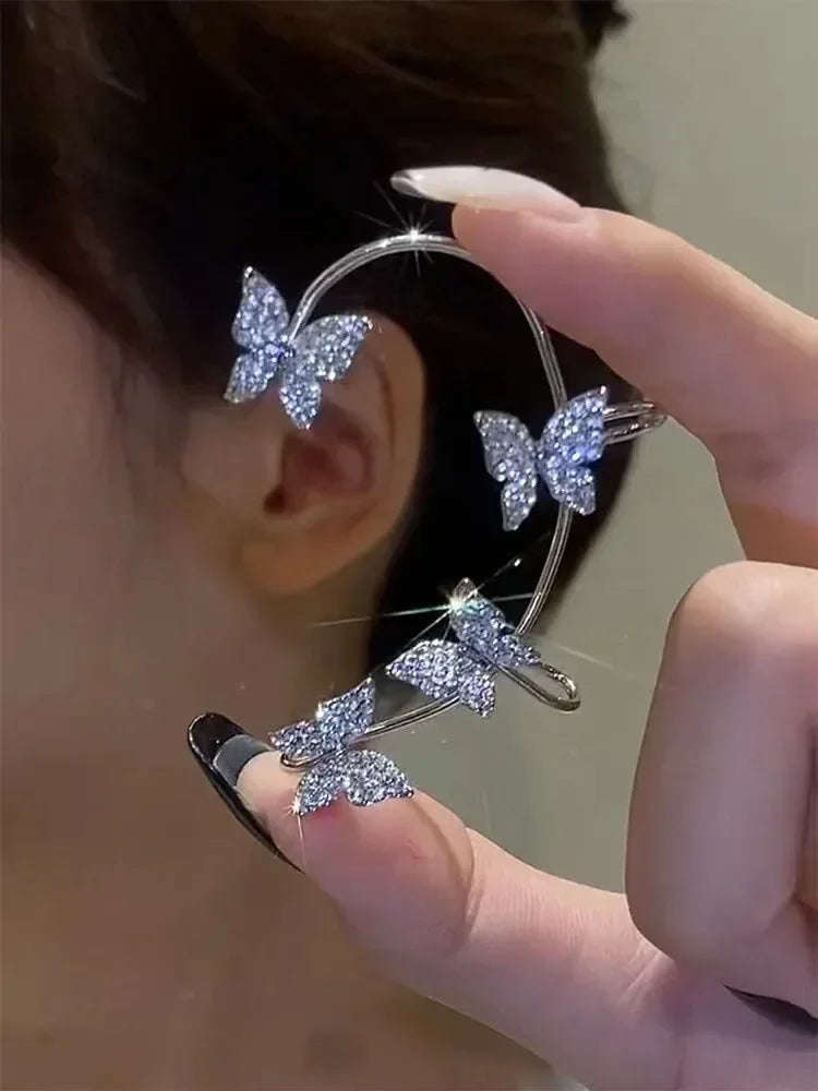 Silver butterfly ear cuff on ear, four crystal butterflies on open band