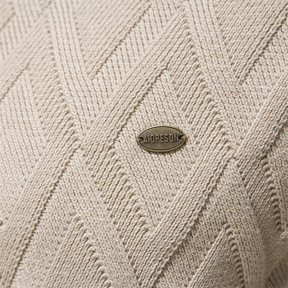 Cream knit sweater close-up with diamond texture and small logo patch