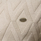 Cream knit sweater close-up with diamond texture and small logo patch
