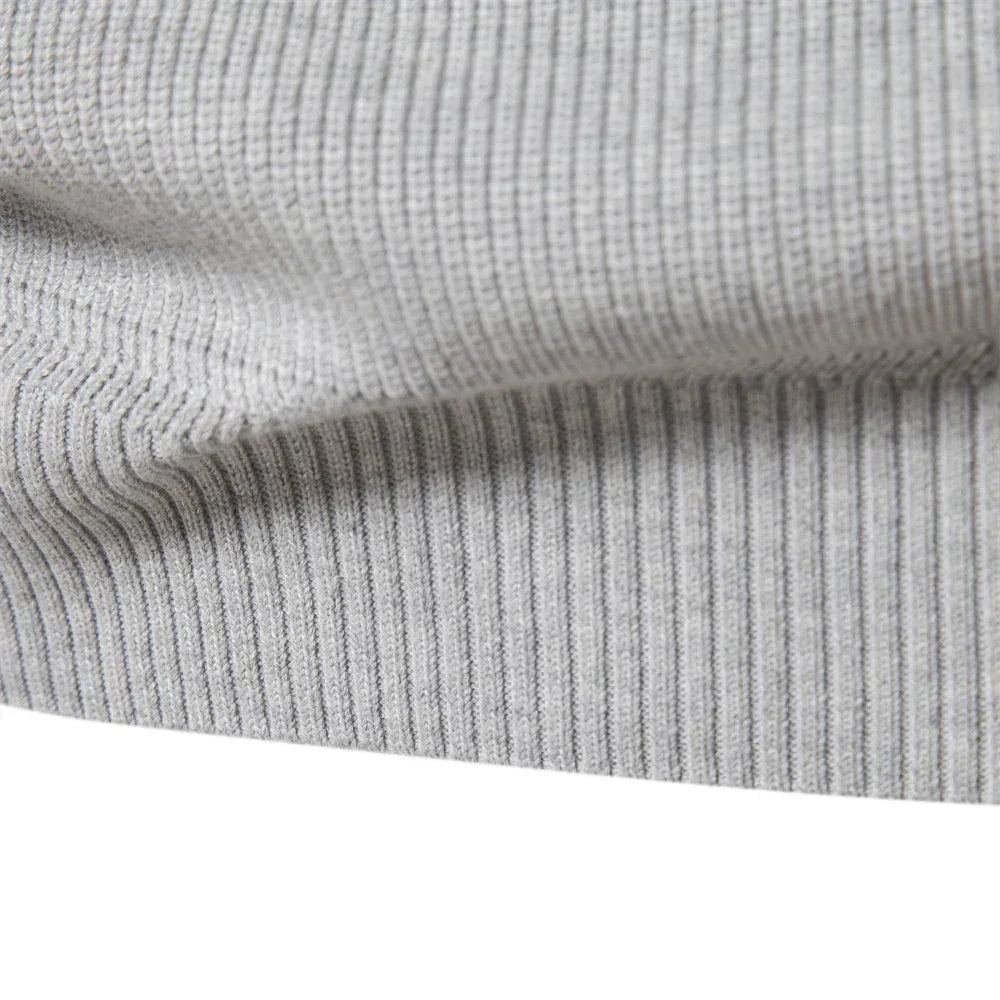 Men's light gray ribbed knit pullover sleeve cuff texture close-up