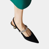 Black pointed-toe slingback heels with rhinestone strap and small block heel