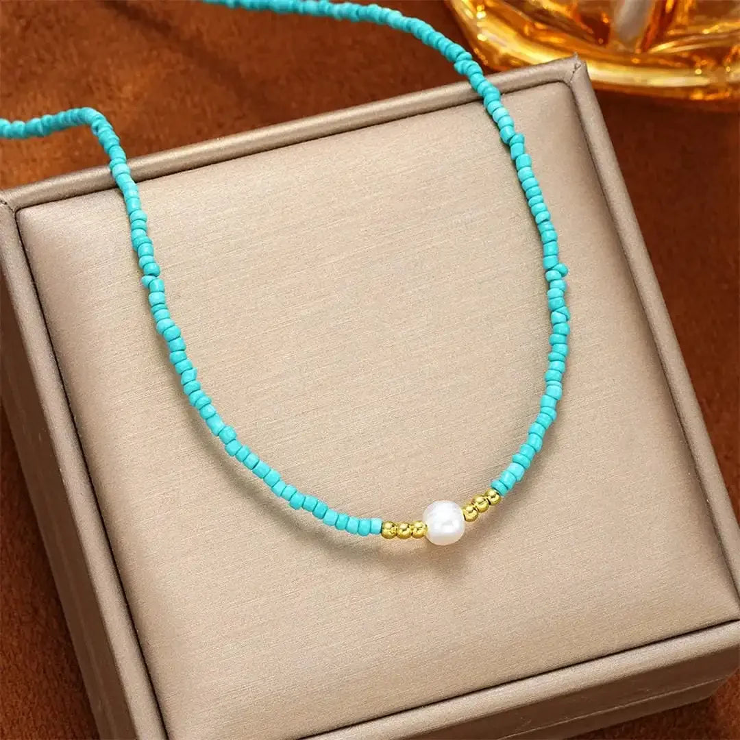 Turquoise beaded necklace on gift box with gold bead detail and white pearl