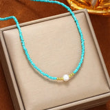 Turquoise beaded necklace on gift box with gold bead detail and white pearl
