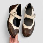 Two-tone classic shoes with buckle strap, brown leather with cream panels and scalloped toe.