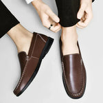 Brown leather slip-on loafers with stitched seams and dark rubber sole