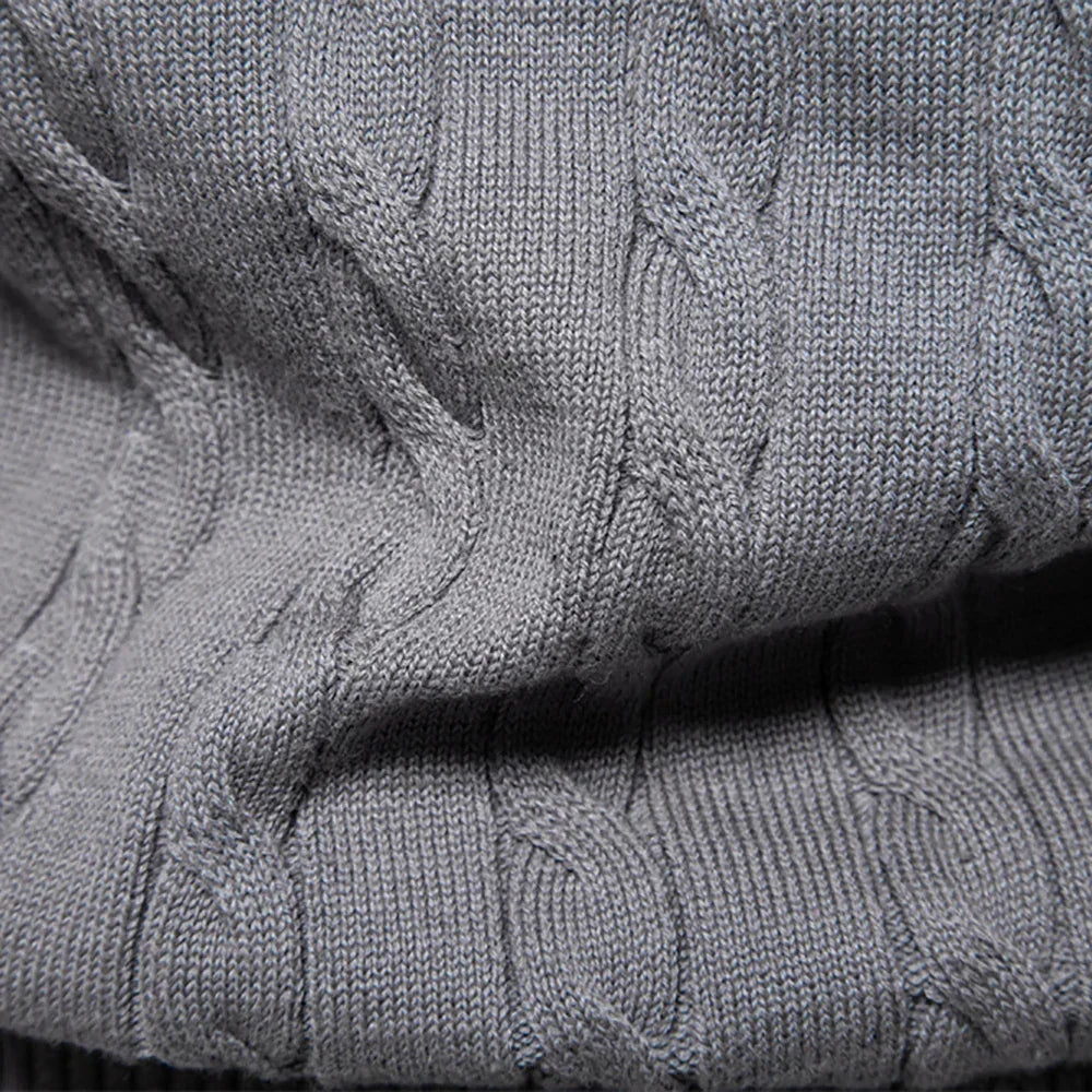 Gray cable-knit sweater close-up with textured shoulder seam