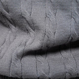 Gray cable-knit sweater close-up with textured shoulder seam