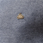 Gold triangular logo on textured knit sweater fabric