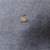 Gold triangular logo on textured knit sweater fabric