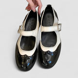 Two-tone classic shoes with buckle strap, black leather with cream panels and toe detailing.