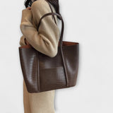 Beige croc-embossed leather tote bag with wide handles and open top