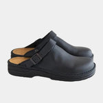 Black clog with adjustable buckle strap and cushioned black rubber sole.