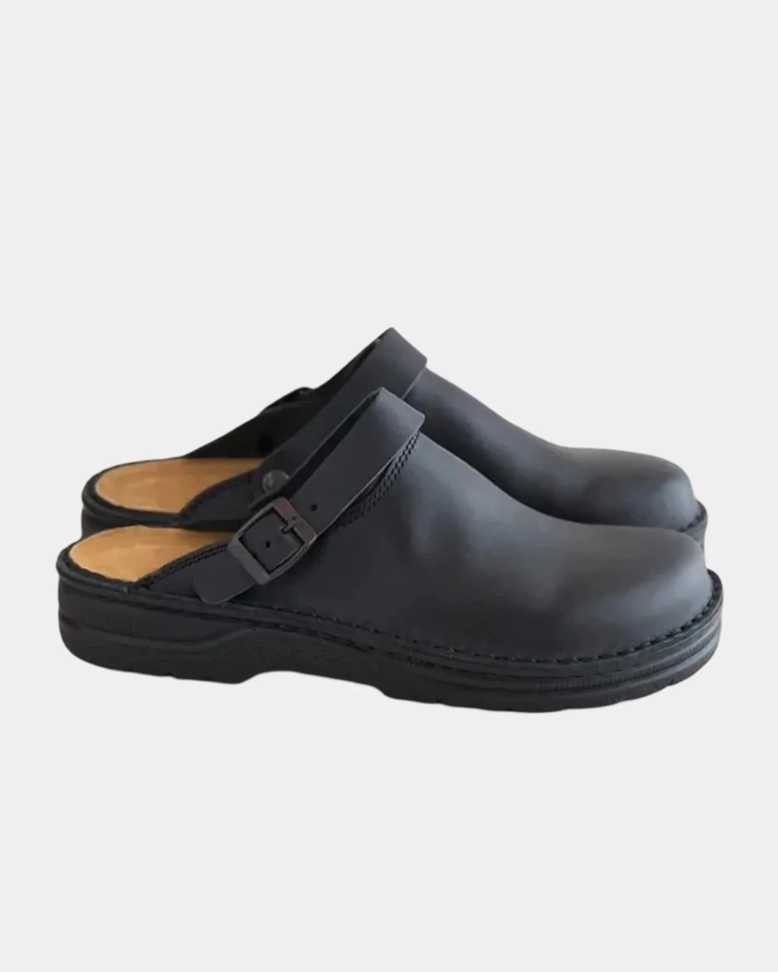 Black clog with adjustable buckle strap and cushioned black rubber sole.