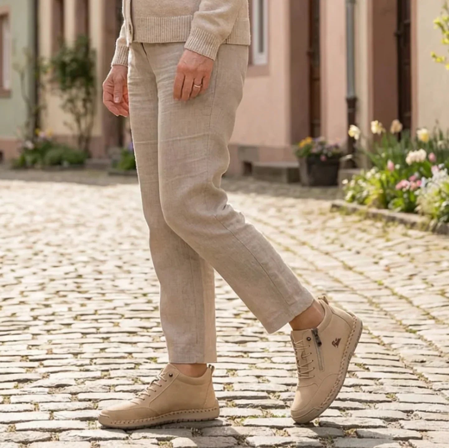 Beige lace-up high-top sneakers with side zipper worn with casual pants.