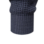 Close-up of dark blue knit sweater hem and cuffs with ribbed texture