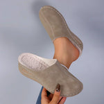 Brown suede-look slip-on slippers with plush inner lining and stitched side trim.