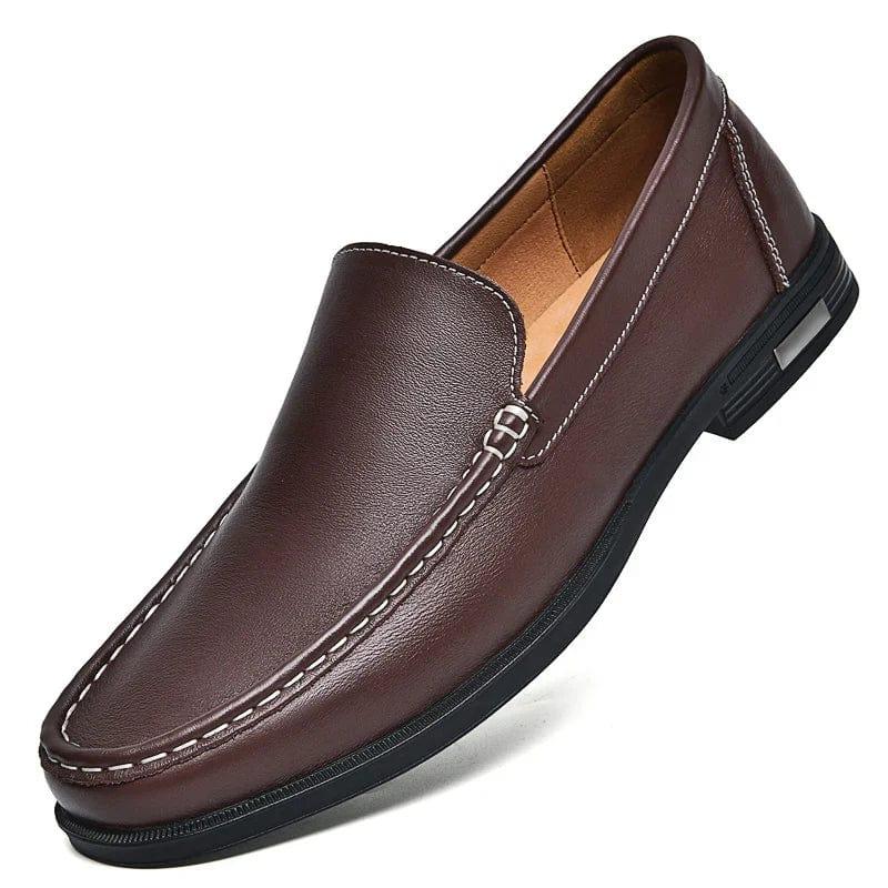 Brown leather loafer with stitched trim, metal buckle strap, and rubber sole