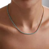 Turquoise stone bead necklace on a gold chain, worn close to neck
