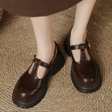 Brown T-bar loafers with gold buckle strap and thick rubber outsole