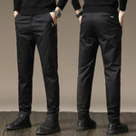 Black slim chino pants with button closure, tapered legs, side pockets and belt loops