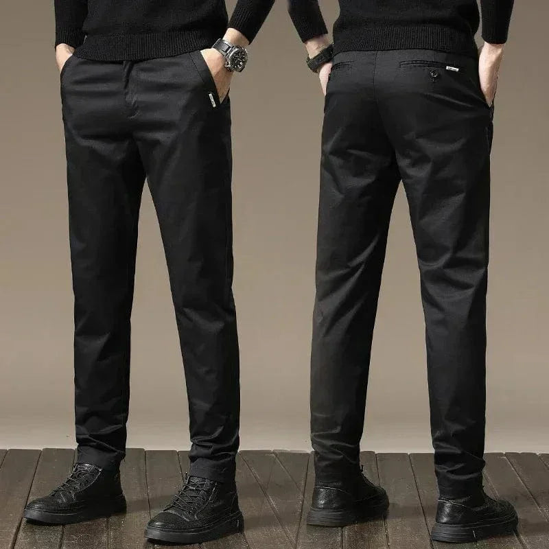 Black slim chino pants with button closure, tapered legs, side pockets and belt loops