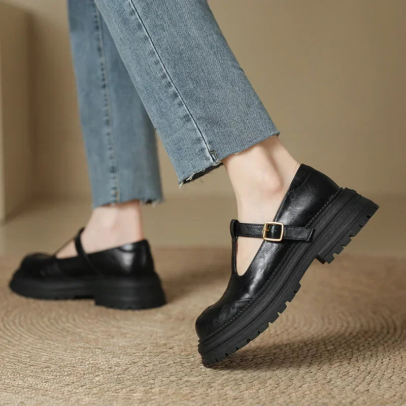 Black leather Mary Jane shoe on foot, T-strap with gold-tone buckle