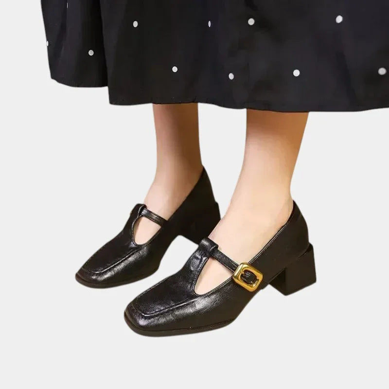 Women's heeled loafer-style shoe in black with gold buckle strap