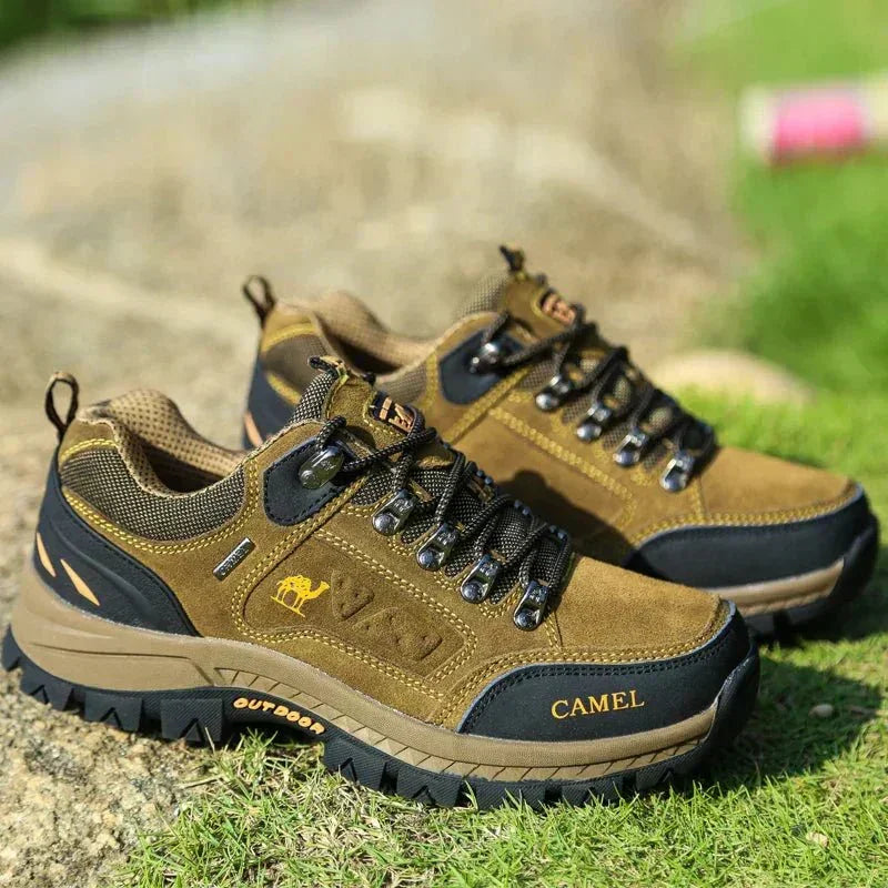Camel-brown lace-up mountain boots with black toe panels and rugged tread outsole