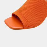 Orange block-heel sandal showing ribbed knit upper and open toe design.