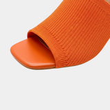 Orange block-heel sandal showing ribbed knit upper and open toe design.