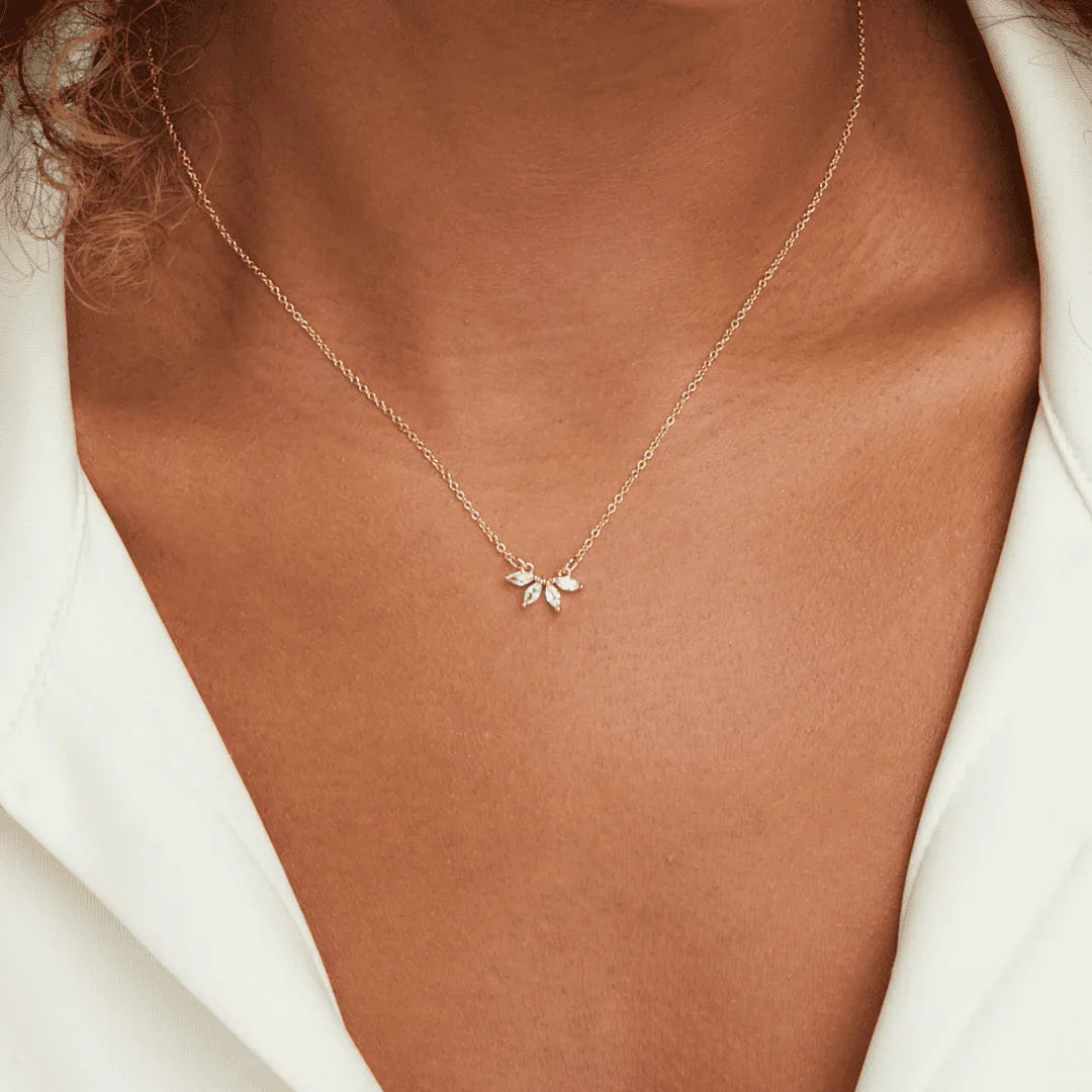 Gold crystal leaf necklace on collarbone, small leaf-charm pendant