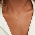 Gold crystal leaf necklace on collarbone, small leaf-charm pendant