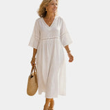 White midi dress with V-neck, short sleeves, embroidered trim, gathered waist