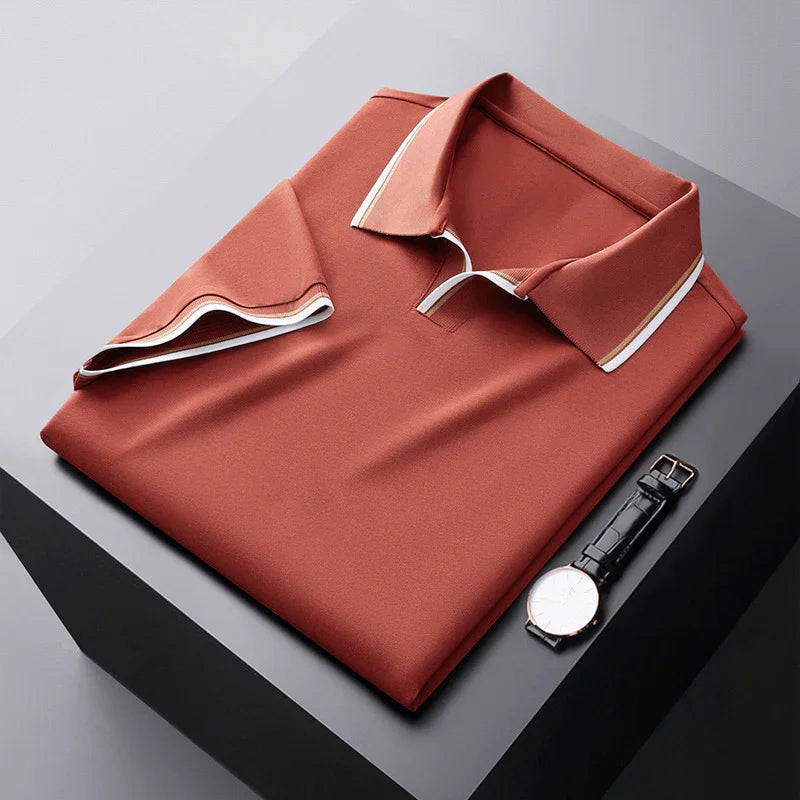 Rust orange soft silk polo shirt, folded flat with contrast-trim collar