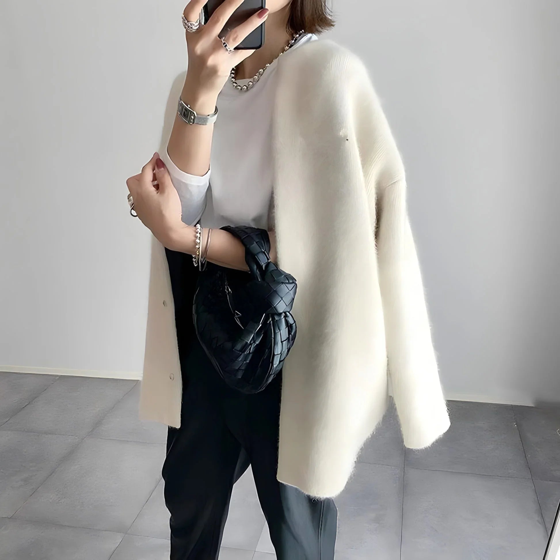 Ivory/cream button cardigan with long sleeves and straight hem, worn over a top.
