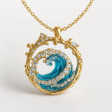Gold ocean wave pendant necklace with blue enamel swirl, ornate frame and clear stones