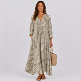 Leaf-pattern summer dress with V-neck, gathered waist, long sleeves, tiered skirt.