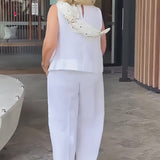 White back view sleeveless top and wide-leg pants with embellished scarf