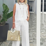 White sleeveless top and wide-leg pants with long beaded necklace