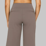 Back view of taupe wide-leg pants with welt pocket accents and straight legs.