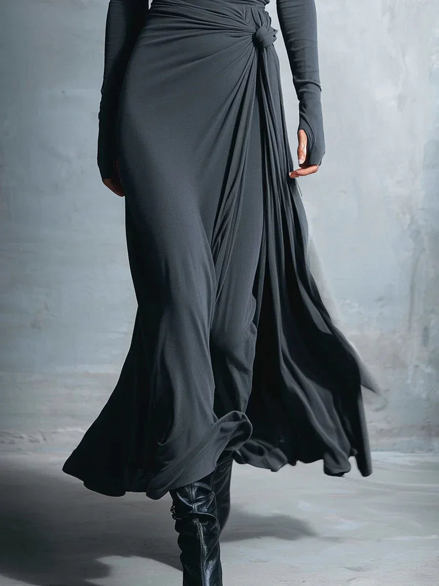 Charcoal gray draped maxi dress close-up with ruched knot and layered skirt folds