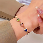 Heart charm bracelet with gold-tone chain and multicolor heart stones on wrist