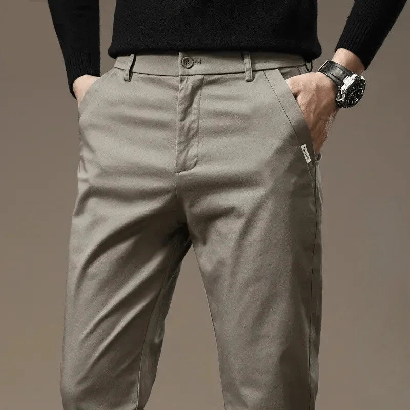Beige-gray slim chino pants with button closure and belt loops, tapered fit