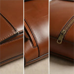 Caramel leather backpack close-up of stitching, flap edge, and brass zipper pull