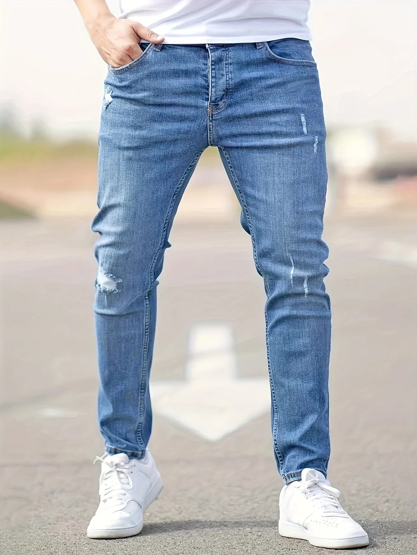 Slim-fit ripped jeans in medium blue, distressed knees and tapered leg openings
