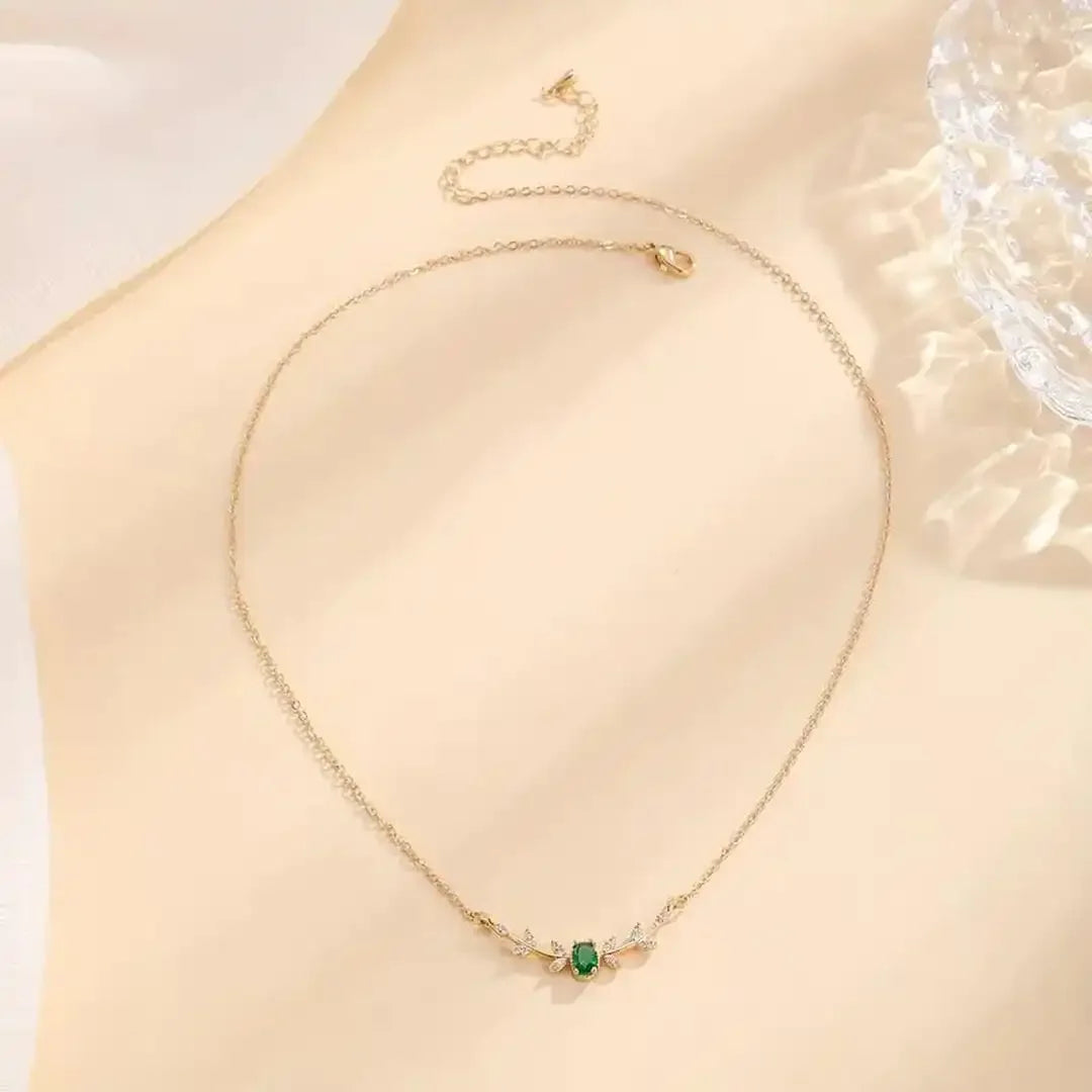 Gold pendant necklace with green marquise leaf stone centerpiece