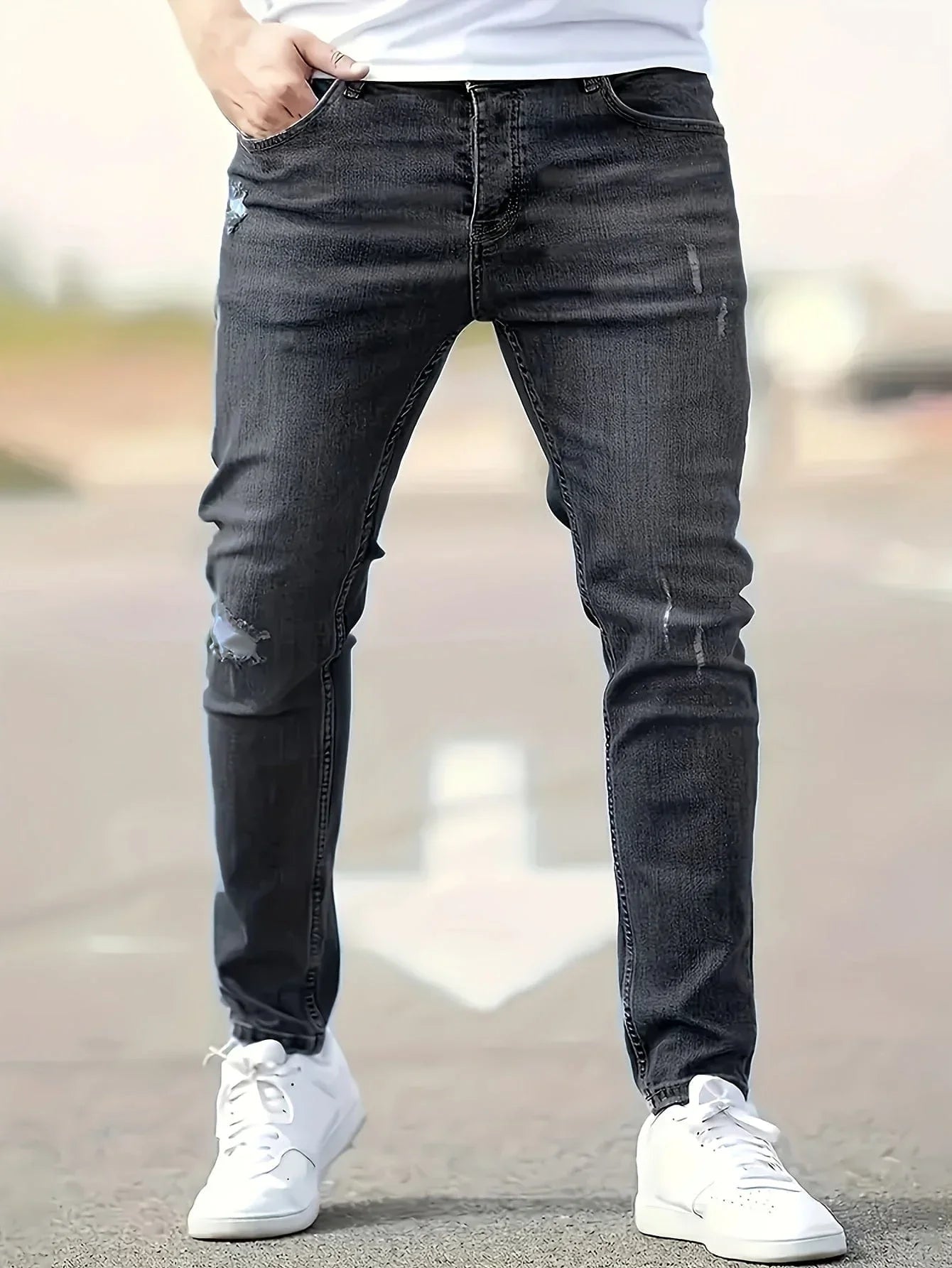 Slim-fit ripped jeans in black wash, distressed knees and fitted straight legs